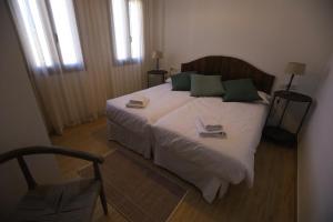 a bedroom with a large bed with two books on it at La Cancela Apartamentos Turísticos in El Rocío
