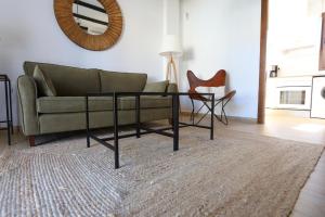 a living room with a couch and a table at La Cancela Apartamentos Turísticos in El Rocío +16 photos
