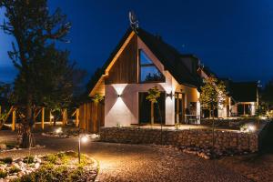 a house with a gambrel roof at night at Osada Białka Tatrzańska - apartamenty & domki z ogrodem dla rodzin Odkryj-Bialke in Białka Tatrzanska