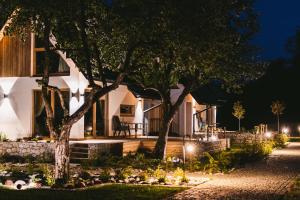 a home at night with trees and lights at Osada Białka Tatrzańska - apartamenty & domki z ogrodem dla rodzin, Odkryj-Bialke in Białka Tatrzańska