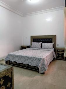 a bedroom with a large bed in a white room at Ritaj Apartement in Marrakesh