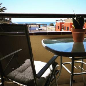 a table and chair on a balcony with a view of the ocean at Casa Árida, Morro Jable in Morro del Jable