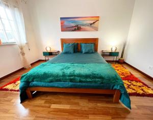 1 dormitorio con 1 cama grande y edredón verde en Amarelaje, en Serra d'El-Rei