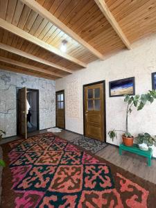 een kamer met een tapijt en een houten deur bij Guest House Guljan in Bokonbayevo