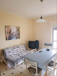 a dining room with a table and a bed at Appartamento con vista sul mare in Marina di Gioiosa Ionica