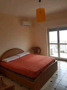 a bedroom with a large bed with a red blanket at Appartamento con vista sul mare in Marina di Gioiosa Ionica
