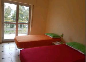 2 camas en una habitación con ventana en Appartamento con vista sul mare, en Marina di Gioiosa Ionica