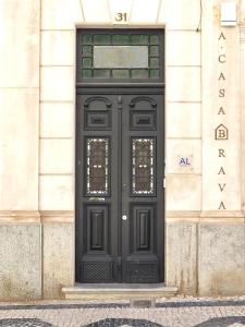 uma porta preta no lado de um edifício em A Casa Brava em Santarém