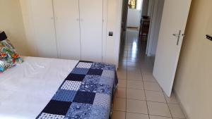 a bedroom with a bed with a blue and white quilt at Adarissa House in Rabat