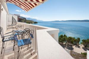 a balcony with a table and chairs overlooking the water at Apartments Gordana in Lokva Rogoznica