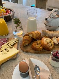 a table with a bunch of breakfast foods and milk at No12 in Mansle