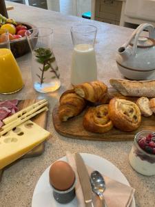 ein Tisch mit einer Auswahl an Frühstücksspeisen und Milch in der Unterkunft No12 in Mansle