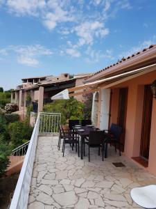 een patio met een tafel en stoelen op een balkon bij Villa mit großartigem Panoramablick auf das Meer und direkt am Pool in La Croix-Valmer