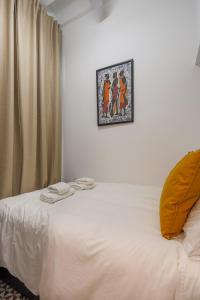 a bedroom with a white bed with a picture on the wall at Cantabria 10 in Seville