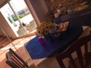un tavolo con una tovaglia blu e fiori sopra di B&B Hollywood - Parcheggio Privato a Porto Cesareo