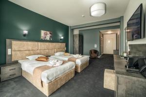 um quarto de hotel com duas camas e uma televisão em Hotel Nordic Twins em Rădăuţi