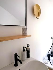 a bathroom sink with two bottles of soap and a mirror at Unique city centre house with log burner & courtyard in Norwich