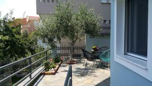a balcony with a table and chairs and a tree at HOPE HOUSE in Kavála
