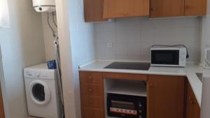 małą kuchnię ze zlewem i kuchenką mikrofalową w obiekcie Santa Pola beach 2 habitaciones w mieście Santa Pola +1 zdjęcie