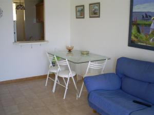 ein Wohnzimmer mit einem blauen Sofa und einem Tisch in der Unterkunft Santa Pola beach 2 habitaciones in Santa Pola