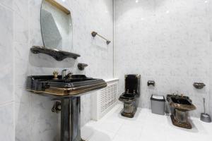 a bathroom with a black sink and a toilet at New Friends Mini-Hotel in Tashkent