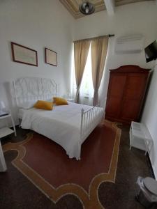 ein Schlafzimmer mit einem weißen Bett und einem Fenster in der Unterkunft La Locanda di San Biagio in Bolzaneto