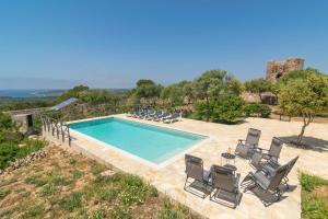 a swimming pool with a bunch of chairs around it at Talaia d'Artrutx in Ciutadella