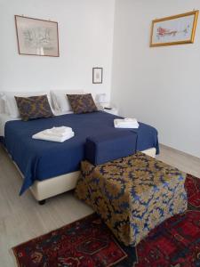 テッラジーニにあるVilla Serendipity Terrasiniのベッドルーム(ベッド2台、オットマン付)