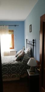 een slaapkamer met een bed met kussens en een raam bij Casa Herbellas in Cedeira