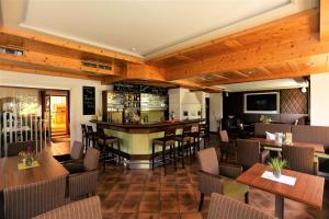 ein Restaurant mit einer Bar sowie Tischen und Stühlen in der Unterkunft Hotel Edelweiss in Maria Alm am Steinernen Meer