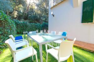 a table and chairs sitting on the grass at Casa Playa by Sonne Villas in Ferreries