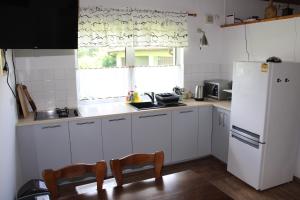 a kitchen with white cabinets and a white refrigerator at Domek w NABO in Załuski