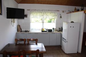 a kitchen with a table and a white refrigerator at Domek w NABO in Załuski