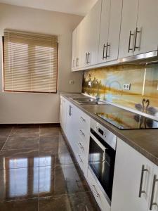 a kitchen with white cabinets and a sink at Natalie’s House in Alexandroupoli