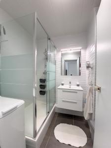 um banheiro branco com pia e chuveiro em Studio CocoCaraïbes Anse des Rochers vue mer - piscine em Belle-Allée