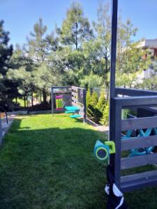 a playground with blue and green benches in the grass at Apartament Zacisze OLO in Niechorze +11 photos