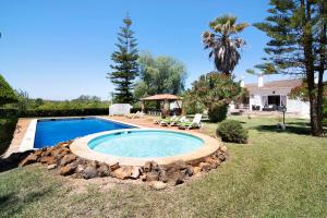 Una piscina en un patio con un cenador. en Casa Alcantarilha, en Pêra
