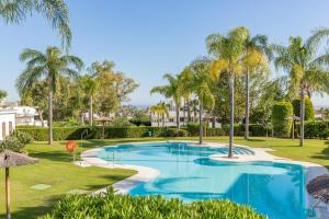een zwembad met palmbomen in een resort bij Holiday Penthouse in Puerto Banus in Marbella