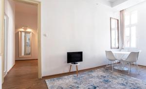 a living room with a tv and a table and chairs at Supreme Luxury Top Central 1 Bedroom Apartment in Sofia