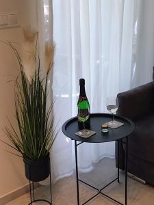 - une bouteille de vin sur une table à côté d'un canapé dans l'établissement Apartament Zacisze OLO, à Niechorze