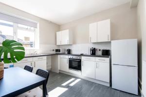 a white kitchen with white appliances and a table at One bedroom apartment in London