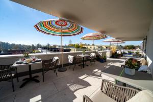 a patio with tables and chairs and umbrellas at bodenseezeit Apartmenthotel Garni in Lindau