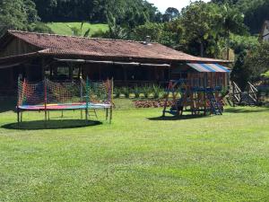 un parco giochi di fronte a un edificio con una casa di Recanto da Roca a Domingos Martins