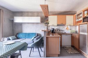 a kitchen and a living room with a couch at Le Skieur in Saint-Léger-les-Mélèzes