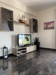 a living room with a flat screen tv on a cabinet at Natalie’s House in Alexandroupoli