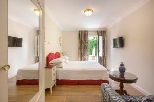 sypialnia z 2 łóżkami i oknem w obiekcie Kouneni Apartments w mieście Mykonos