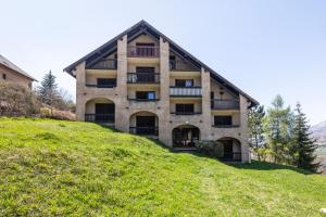 un bâtiment au sommet d'une colline herbeuse dans l'établissement Le Skieur, à Saint-Léger-les-Mélèzes