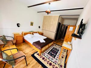 a bedroom with a bed and a chair at Pensiunea Casa Boiereasca in Peştera