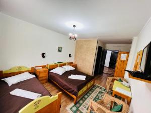 a bedroom with a bed and a couch and chairs at Pensiunea Casa Boiereasca in Peştera