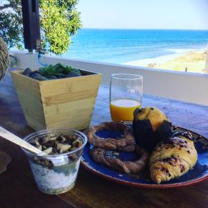 une assiette de nourriture avec des anneaux d'oignon et un verre de jus d'orange dans l'établissement Shambala Beach House-where mountains meet the sea, à Pomos